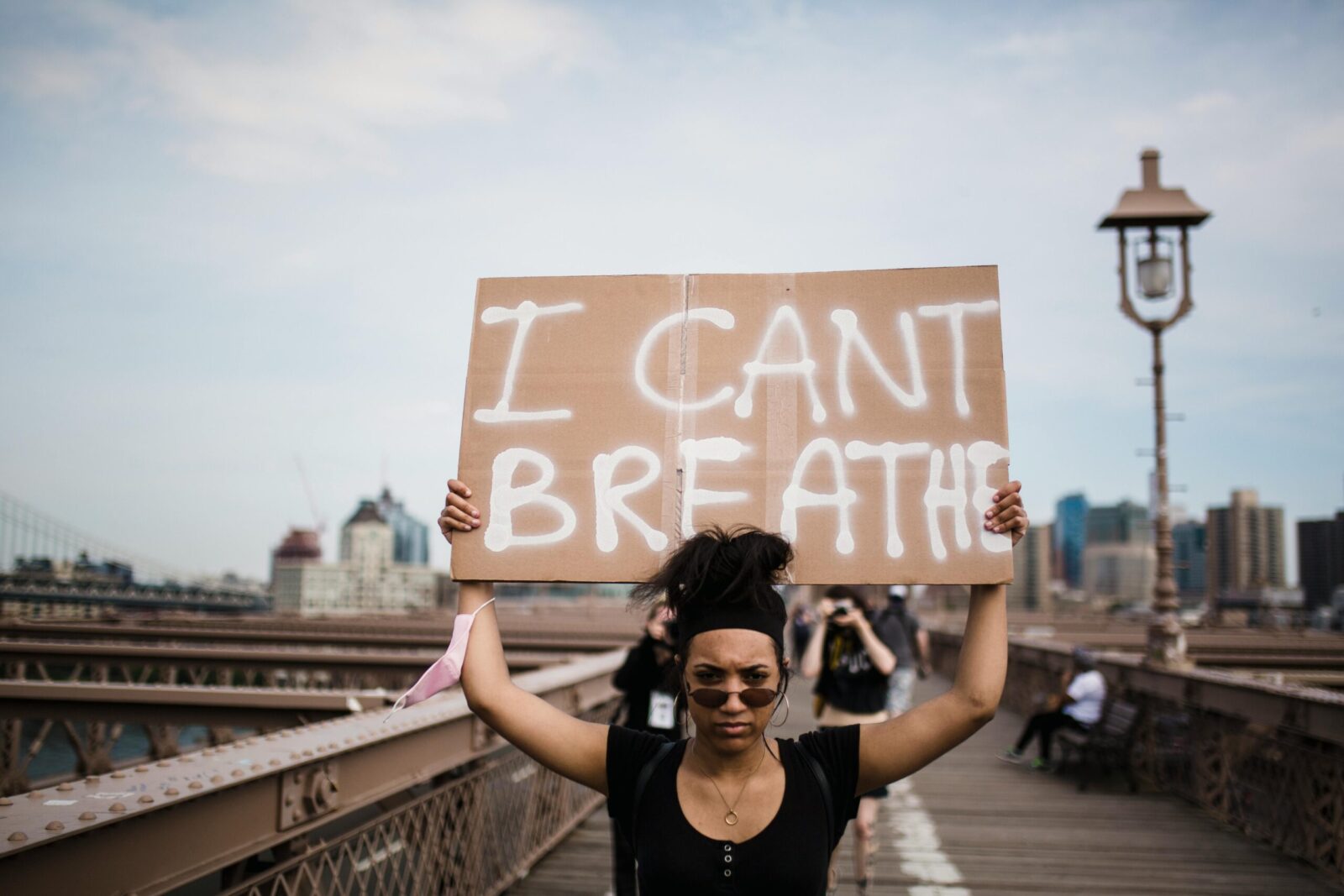 A protester holds an 'I Can't Breathe' sign during a demonstration on a bridge.